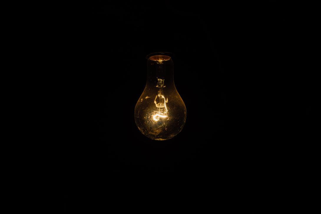 A lightbulb dimly illuminating a dark space
